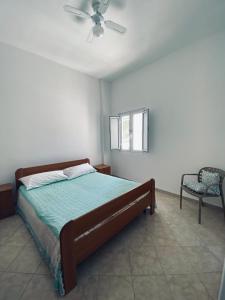 a bedroom with a bed and a ceiling fan at Casa Vacanze , Scoglitti in Scoglitti