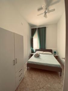 Schlafzimmer mit einem Bett und einem Deckenventilator in der Unterkunft Casa Vacanze , Scoglitti in Scoglitti