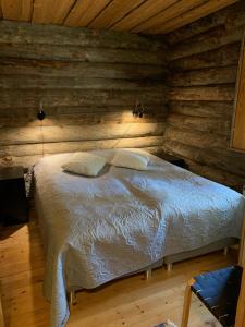um quarto com uma cama num chalé de madeira em Logwood Chalet em Luosto
