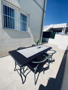 una mesa negra y 2 sillas en un patio en Casa Vacanze , Scoglitti en Scoglitti