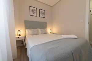 a bedroom with a large white bed and two lamps at Apartamento el centro in Logroño