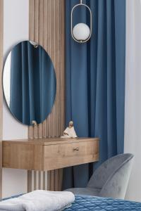 コウォブジェクにあるBaltic Marina Residence Apartments by Noclegi Rentersの鏡と青いカーテンが付いた化粧台