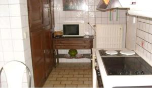 a small kitchen with a stove and a microwave at PROPRIETE BORDEE D'ETANGS, PROPICE A LA DETENTE in Florenville