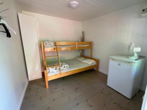 Habitación pequeña con litera y nevera. en Aspan Kurs & Lägergård en Ronneby