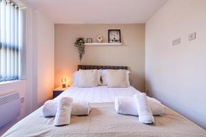 a bedroom with a large bed with two pillows at Stunning 1 bed apartment in the heart of Stockport in Stockport