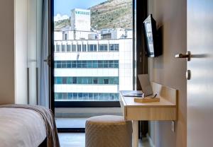 a room with a bed and a desk with a window at Four Blue Seasons - Luxury Apartments Dubrovnik in Dubrovnik