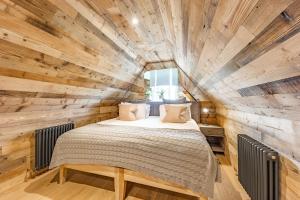 1 dormitorio con 1 cama en una pared de madera en No1 Apartments & Bedrooms St Andrews - St Mary's en St Andrews