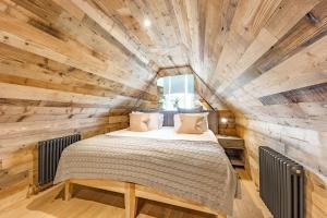 a bedroom with a bed in a wooden wall at No1 Apartments & Bedrooms St Andrews - St Mary's in St. Andrews