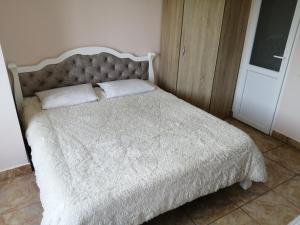 a bed with a white blanket and pillows on it at Black Sea STAR in Chornomorsk