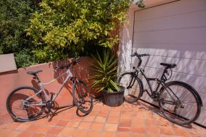 Dos bicicletas están estacionadas al lado de un garaje. en Villa Carpe Diem, en Le Lavandou
