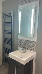 bagno con lavandino bianco e specchio di CityGo Apartments Queens Wellington a Belfast