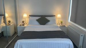 una camera da letto con un grande letto con due comodini di CityGo Apartments Queens Wellington a Belfast