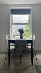 a dining room table and chairs with a vase on it at CityGo Apartments Queens Wellington in Belfast