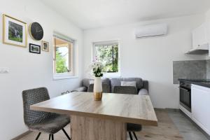 a kitchen and living room with a wooden table at Apartments Green Linden in Rakovica