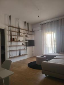 un soggiorno bianco con divano e tavolo di SKY Apartment a Vlorë