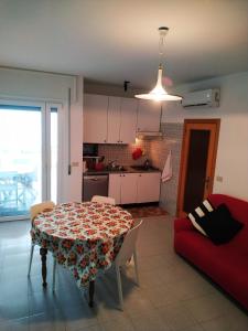 福薩切西亞的住宿－LaMagnolia，客厅配有桌子和红色沙发