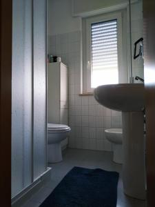 ein Bad mit einem Waschbecken, einem WC und einem Fenster in der Unterkunft LaMagnolia in Fossacesia