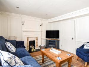 a living room with a blue couch and a table at The Little Rose in Lyme Regis