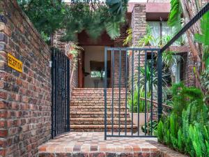 a brick building with a gate in front of a house at Cosy-Corner Guest House, George in George