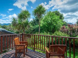 a deck with two chairs and palm trees at Cosy-Corner Guest House, George in George