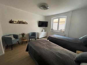 a bedroom with two beds and a chair and a window at Fewo ToNi in Wismar