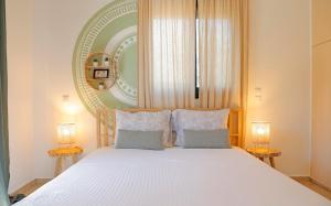 a bedroom with a large white bed with two lamps at Oliva Holiday Homes in Dhiyeliótika