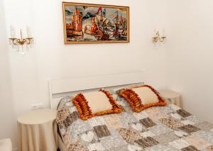 a bed with two pillows and a picture on the wall at Casa Murraglia No 4 in Piran