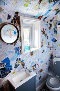 a bathroom with a toilet and a sink and a mirror at Kippers Cottage in Cromer