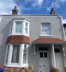 una casa gris con una puerta y ventanas blancas en Stay Llandudno, en Llandudno