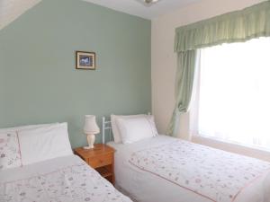 - une chambre avec 2 lits et une fenêtre dans l'établissement Stay Llandudno, à Llandudno