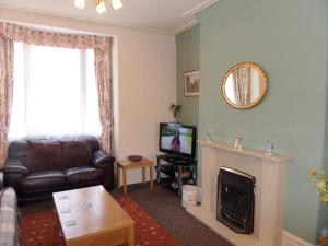 Una sala de estar con un sofá y una chimenea. en Stay Llandudno, en Llandudno 2 fotos más