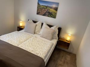 um quarto com uma cama com almofadas e uma fotografia na parede em Ferienwohnung Andexlinger em Abtenau