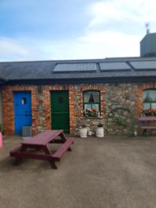 a picnic table in front of a brick building at Slane Farm Hostel, Cottages and Camping in Slane
