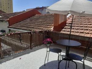 ein Tisch und zwei Stühle und ein Sonnenschirm auf dem Balkon in der Unterkunft Moradia em vila da cidade in Lissabon