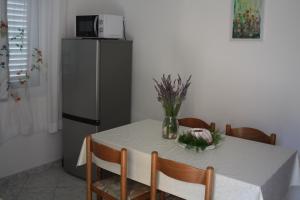 a kitchen with a table with a refrigerator at Apartman Anka in Viganj