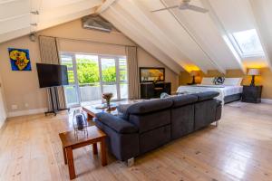 a living room with a couch and a bed at TheLoft32 in Cape Town +18 photos