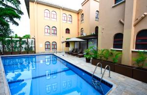 a swimming pool in front of a building at Casa Solada Hotel in Kampala