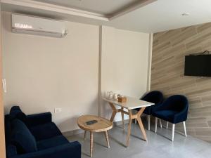 ein Wohnzimmer mit einem Tisch und 2 blauen Stühlen in der Unterkunft Palmo Holiday Apartments in Kathmandu