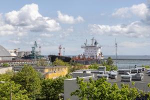a large ship in the water next to the ocean at Coffee Apartment Gdynia in Gdynia