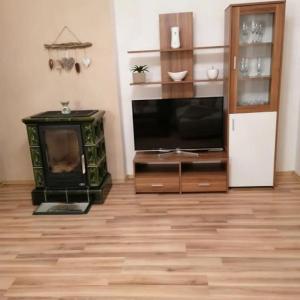 a living room with a fireplace and a television at Ubytovanie Sosna Muráň in Muráň