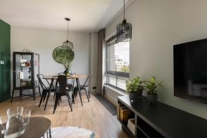 a living room with a table and a television at Coffee Apartment Gdynia in Gdynia