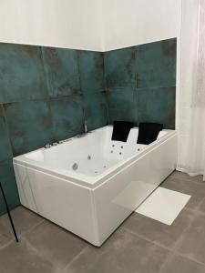 uma banheira branca na casa de banho com paredes verdes em Appartamento Calilla em Taranto