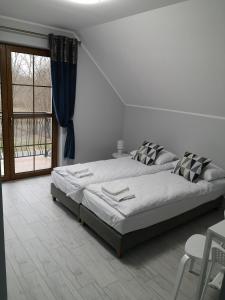 a bedroom with a bed and a large window at Apartamenty, Zielone Wzgórze Wiktora w Mikołajkach in Mikołajki