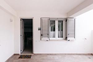 une chambre vide avec des murs blancs et une fenêtre dans l'établissement Le Isole di Anita, à Lipari