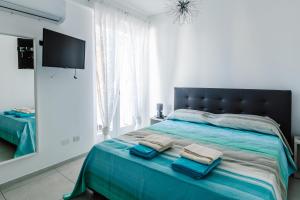 een slaapkamer met een bed met twee handdoeken erop bij Le Isole di Anita in Lipari