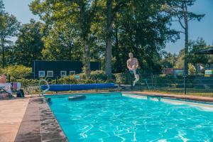 a pool with a statue of a man jumping into the water at EuroParcs Reestervallei in IJhorst