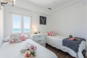 2 camas en una habitación con el océano en el fondo en San José Vistas Mar 2 baños, en Cádiz