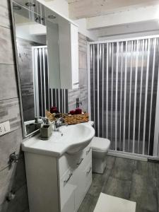a white bathroom with a sink and a toilet at Le Casette tra gli Ulivi in Santa Maria Del Focallo