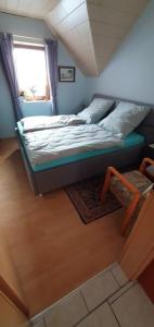 Bett in einem kleinen Zimmer mit Fenster in der Unterkunft Casa Ulla am Hallenbad in Haiger
