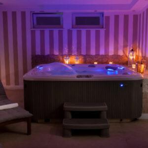 Villa Puerto في بوبيروفو: حوض استحمام في غرفة مع إضاءة أرجوانية